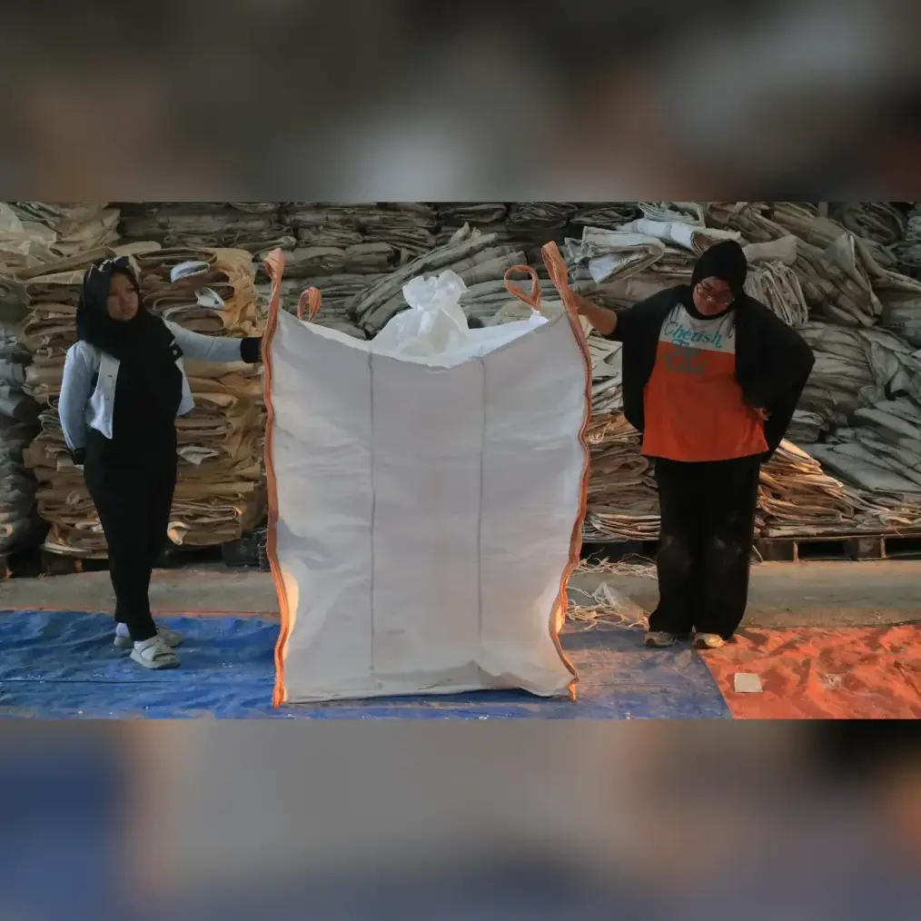 Baffle bag putih dibentangkan dua pekerja di gudang Karung Jumbo Sidoarjo